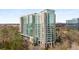 Exterior view of a modern high-rise apartment building with floor-to-ceiling windows and lush landscaping around the building at 3300 Windy Ridge Se Pkwy # 1501, Atlanta, GA 30339