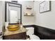 Stylish half bath with vessel sink, dark wood accents, decorative shelves, and art at 4812 Lismoor Sw Trce, Mableton, GA 30126
