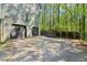 Long driveway leading to a two-car garage, surrounded by mature trees and lush landscaping at 4812 Lismoor Sw Trce, Mableton, GA 30126