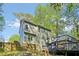 Rear exterior view of the home showcasing the spacious deck and fenced yard with mature trees and landscaping at 4812 Lismoor Sw Trce, Mableton, GA 30126