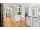 Bright kitchen with white cabinets, stainless fridge, hardwood floors, and view to entry and living room at 4812 Lismoor Sw Trce, Mableton, GA 30126
