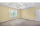 Bright bedroom with tray ceiling, fan, window, and carpet at 8849 Seneca Rd, Palmetto, GA 30268