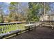 View of the back deck featuring wooden floorboards, white lights, and a beautiful backyard at 940 Austin Ave, Atlanta, GA 30307