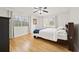 This bedroom features hardwood floors, a ceiling fan, a queen bed, and two large windows for ample natural light at 1468 Briarwood Ne Rd # 810, Brookhaven, GA 30319