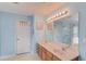 Light blue bathroom featuring double sink vanity, large mirror and bright lighting at 3904 Tristan Way, Suwanee, GA 30024
