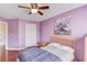 Comfortable bedroom featuring hardwood floors and purple accent wall at 3904 Tristan Way, Suwanee, GA 30024