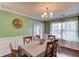 Elegant dining room with wainscoting, hardwood floors, a chandelier, and large windows for ample natural light at 3904 Tristan Way, Suwanee, GA 30024