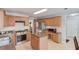 Well-lit kitchen featuring stainless steel appliances, granite countertops, island, and natural wood cabinets at 3904 Tristan Way, Suwanee, GA 30024