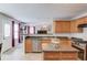 Well-equipped kitchen with stainless steel appliances, granite countertops, and an open view to the living room at 3904 Tristan Way, Suwanee, GA 30024