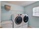 Bright laundry room featuring modern washer and dryer units and ample storage at 3904 Tristan Way, Suwanee, GA 30024