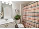 Bright bathroom featuring a decorative shower curtain, vanity, and green plant on the toilet at 558 Carleton Pl, Locust Grove, GA 30248
