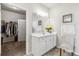 Well lit bathroom with a sink, mirror, decorative accents, and an open door to the closet at 558 Carleton Pl, Locust Grove, GA 30248