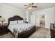 A spacious bedroom with a decorative bed frame, ceiling fan, and an open doorway to a bathroom at 558 Carleton Pl, Locust Grove, GA 30248