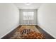Bright bedroom featuring a decorative rug, light gray walls, and natural light from the window at 558 Carleton Pl, Locust Grove, GA 30248