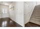 Home entryway featuring hardwood floors, wainscoting, staircase, and access to a room with a glass door at 558 Carleton Pl, Locust Grove, GA 30248