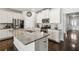 Open-concept kitchen with a large granite island, stainless steel appliances, and white cabinets at 558 Carleton Pl, Locust Grove, GA 30248