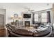 Inviting living room features a cozy fireplace, hardwood floors, and a leather sectional couch at 558 Carleton Pl, Locust Grove, GA 30248