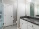 Bathroom with granite countertop, white cabinets, framed mirror, and glass enclosed shower with tiled walls at 62 Emerson Hill Sq, Marietta, GA 30060