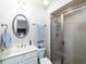 Clean bathroom featuring a vanity with an oval mirror, a shower stall, and blue decorative towels at 62 Emerson Hill Sq, Marietta, GA 30060