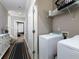 Convenient laundry room area with washer, dryer, and shelving for supplies located off the hallway at 62 Emerson Hill Sq, Marietta, GA 30060