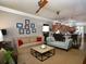 Open living room featuring a ceiling fan, beige sofa, chaise lounge, and kitchen access at 62 Emerson Hill Sq, Marietta, GA 30060