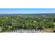 A distant aerial shot showcases a neighborhood nestled among lush green trees and a clear blue sky at 163 Neese Farm Dr, Woodstock, GA 30188