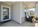 Inviting front porch with seating, stone accents, and well-maintained landscaping, creating a welcoming entryway at 163 Neese Farm Dr, Woodstock, GA 30188