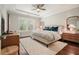 Comfortable main bedroom with tray ceiling, ceiling fan, and natural light from the large windows at 163 Neese Farm Dr, Woodstock, GA 30188