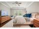 Comfortable main bedroom with tray ceiling, ceiling fan, and natural light from the large windows at 163 Neese Farm Dr, Woodstock, GA 30188