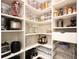 Organized walk-in pantry with shelving and storage containers for food and kitchen appliances at 163 Neese Farm Dr, Woodstock, GA 30188