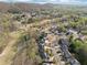 Aerial view of a community featuring well-maintained homes, tree-lined streets, and a nearby green golf course at 6840 N Creekside Pt, Cumming, GA 30041