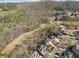 An aerial view of neighborhood showcasing well-maintained homes, mature trees, and a community golf course in the distance at 6840 N Creekside Pt, Cumming, GA 30041