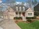 Charming brick home boasts an inviting front porch, manicured landscaping, and a two-car garage, creating excellent curb appeal at 6840 N Creekside Pt, Cumming, GA 30041