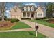 Charming brick home showcasing a manicured front lawn, welcoming porch, and a two-car garage at 6840 N Creekside Pt, Cumming, GA 30041