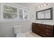 Bathroom features a dark wood vanity with a white countertop, toilet, and a window, creating a functional space at 1811 Tilliewood Ne Trl, Marietta, GA 30066