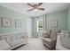 Bright Bedroom featuring a crib, comfortable glider, and soft, neutral tones that create a relaxing atmosphere at 1811 Tilliewood Ne Trl, Marietta, GA 30066