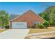 Brick home exterior with a two-car garage and a well-manicured lawn at 5780 Village Loop, Fairburn, GA 30213