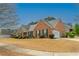 Side view of the attractive brick house with attached garage and manicured landscaping at 5780 Village Loop, Fairburn, GA 30213