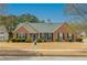 Charming brick home featuring green shutters, a well-maintained lawn, and a welcoming entrance at 5780 Village Loop, Fairburn, GA 30213
