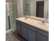 Bright bathroom features a double sink vanity with grey cabinets and a glass-enclosed shower at 184 Grafton St, Hampton, GA 30228