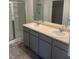 Bright bathroom features a double sink vanity with grey cabinets and a glass-enclosed shower at 184 Grafton St, Hampton, GA 30228