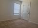 This bedroom features neutral carpet, a window with blinds, and a white door at 184 Grafton St, Hampton, GA 30228