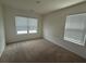 Neutral bedroom with two windows offering ample natural light, neutral carpet, and fresh paint ready for personalization at 184 Grafton St, Hampton, GA 30228