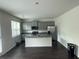This spacious kitchen features gray cabinets, granite countertops, stainless steel appliances and a large island at 184 Grafton St, Hampton, GA 30228