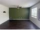 Spacious living room with wood flooring, a ceiling fan, and natural light from a large window at 184 Grafton St, Hampton, GA 30228