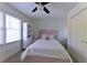 Cozy bedroom with a pink upholstered headboard, ceiling fan, and a large window at 3811 Valley Green Dr, Marietta, GA 30068