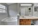 Bright bathroom featuring a tub and vanity with wood cabinets and a large mirror at 2274 Stancrest Ln, Lawrenceville, GA 30044