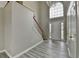 Foyer view shows staircase, and light gray walls and gray wood-look floors at 2274 Stancrest Ln, Lawrenceville, GA 30044