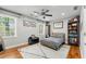 Sunlit bedroom with hardwood floors, a ceiling fan and a cozy gray blanket at 292 Old Rosser Rd, Stone Mountain, GA 30087