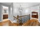 Upstairs hallway with hardwood floors, modern lighting, and views into a bathroom and bedroom at 292 Old Rosser Rd, Stone Mountain, GA 30087